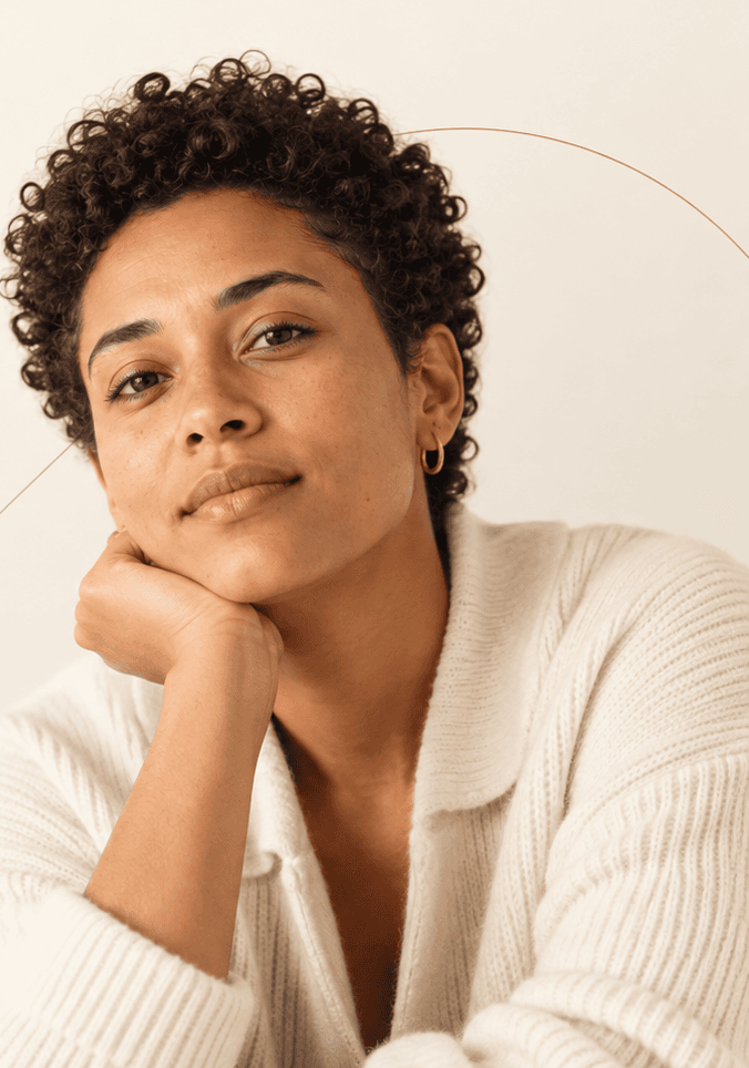 A woman resting her chin in her hand, looking calmly toward the viewer